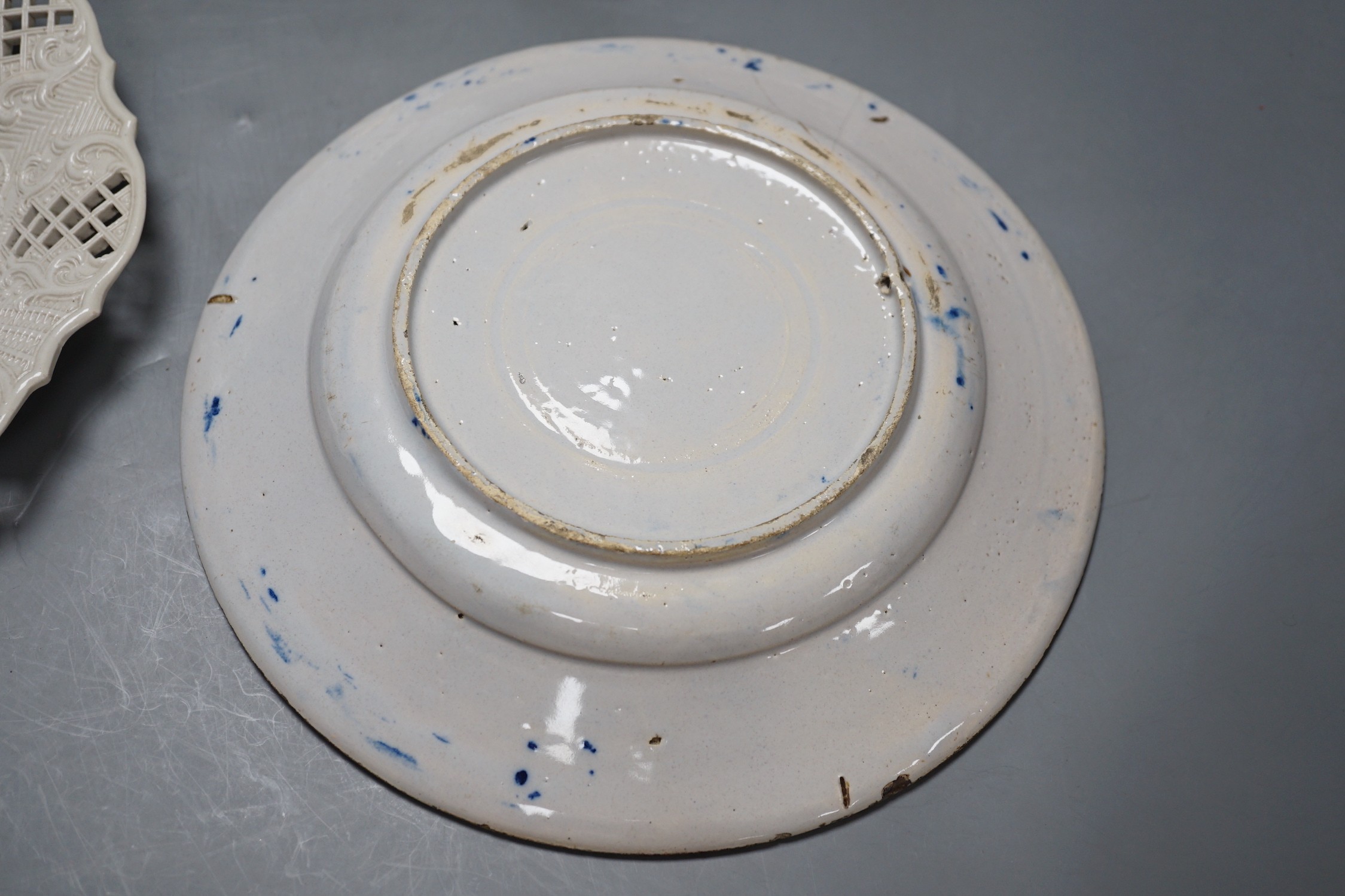 A Staffordshire salt glaze plate with pierced border, a Staffordhire tortoiseshell painted plate, a creamware underglaze blue plate and a Dutch delft plate, salt glazed plate 21 cms diameter